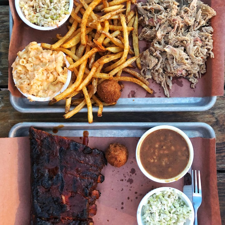 The Pig Plate with Mac + Cheese and Fries and the Ribs Plate with beans and hushpuppies from Sauceman's
